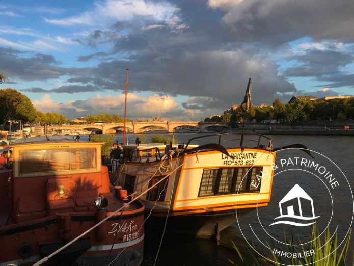 Péniche sur les quais de Seine avec une vue dégagée à couple d'un bateau avec baisse de prix COT.