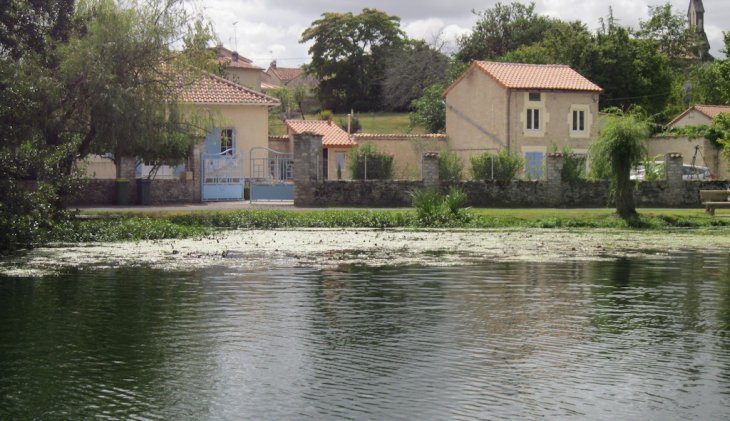 Maison en pierre et jardin verdoyant bordés par une rivière paisible, lieu de vie d'un de nos clients