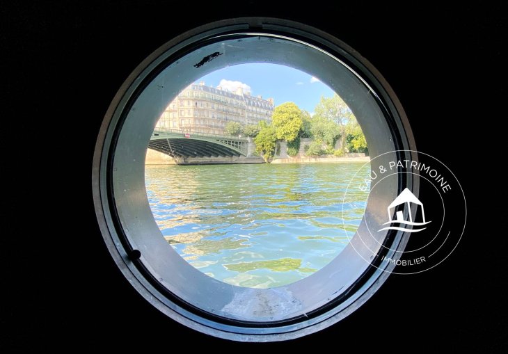 Télétravail avec vue sur l'eau dans le bureau d'une péniche d'architecte en vente à Paris.