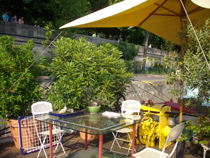 Témoignage client satisfait: Terrasse conviviale d'une péniche, avec table et végétation, sous un parasol jaune